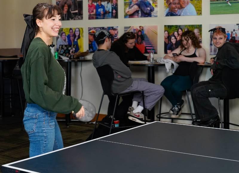 a student plays ping pong in the student center